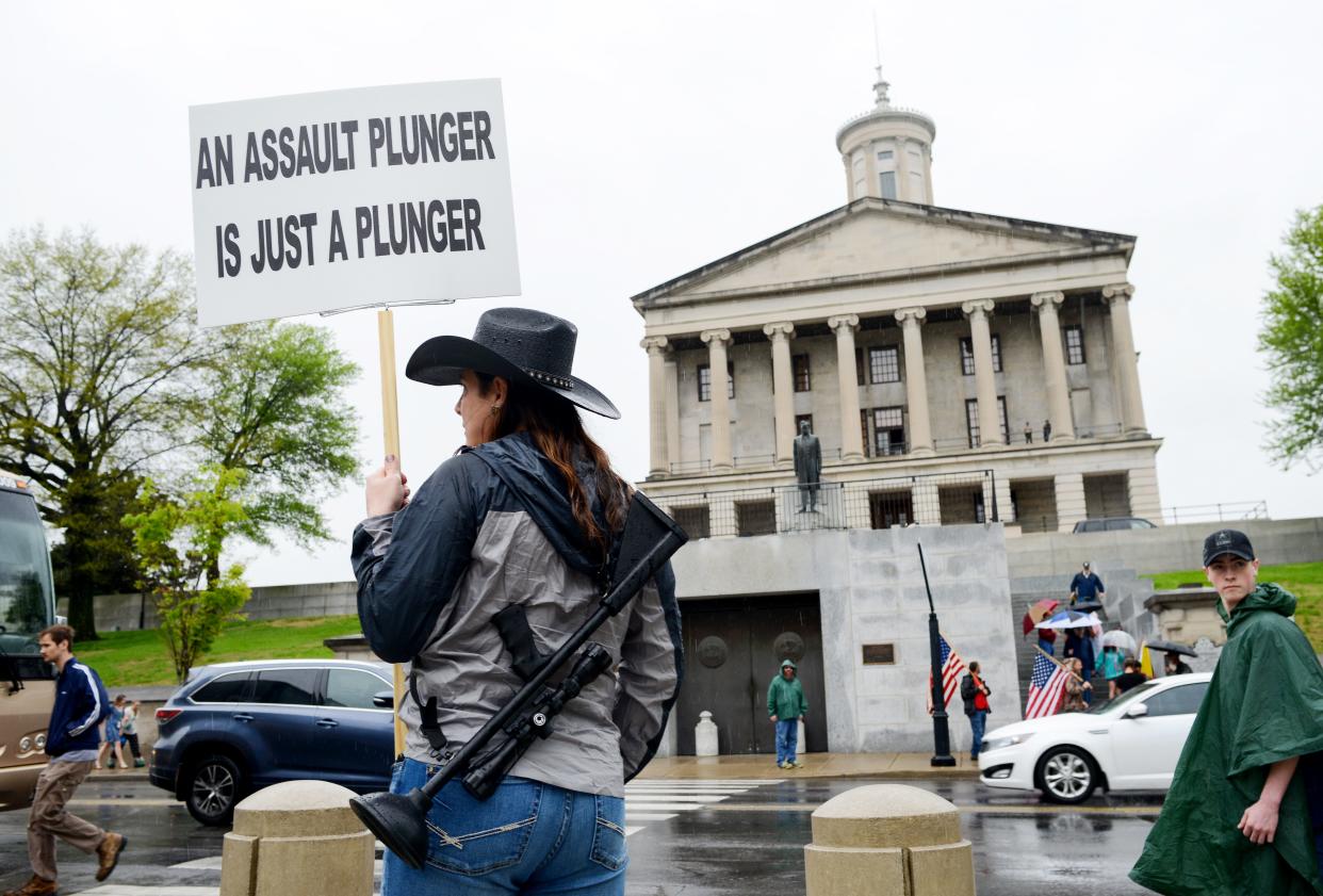 A woman, who wished not to be identified, carries a custom made "assault plunger," as she joins other supporters of gun-rights and the second amendment at the Tennessee state Capitol April 14, 2018.