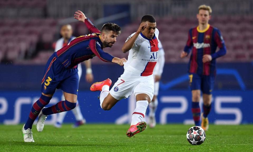 Kylian Mbappé powers away from Barcelona’s Gerard Piqué.