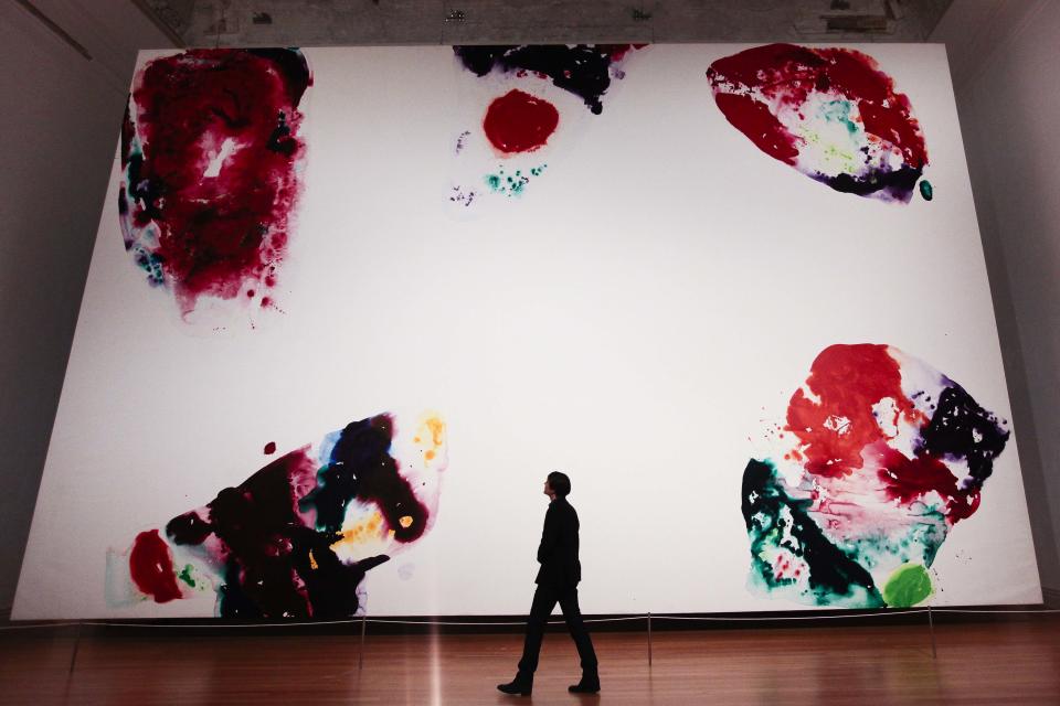 A man walks in front of the giant painting 'Berlin Red' (1969-1970 ) by artist Sam Francis during a press preview of the exhibition 'Pazific Standart Time' in Berlin Wednesday, March 14, 2012. The exhibition that offers viewers a primer on three decades of Los Angeles' diverse art scene and stems from a decade of research is going on show in Berlin from March 15. until June 10, 2012. (AP Photo/Markus Schreiber)