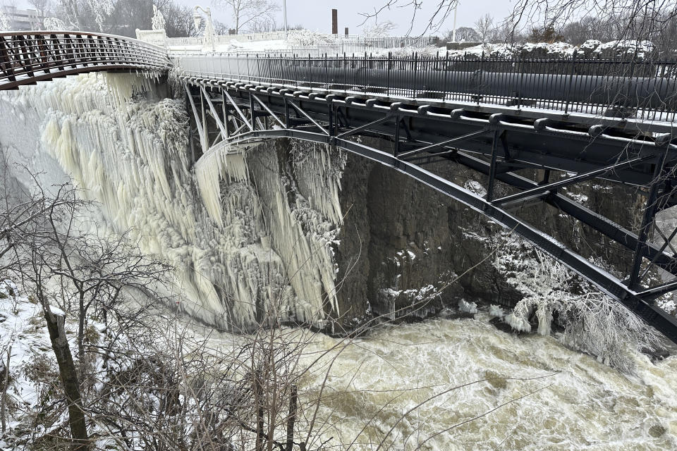 Mist from the Great Falls has created a frozen wonderland around the waterfalls in Paterson, N.J., on Thursday, Jan. 18, 2024. People are braving the subfreezing cold temps and slippery walkways to visit the ice-covered trees, benches and lamp posts. (AP Photo/Ted Shaffrey)