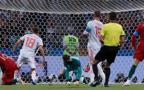 Spain goalkeeper David De Gea, in green, looks round as the ball goes into the net as Portugal's Cristiano Ronaldo, right scores his sides 2nd goal - Credit: Manu Fernandez/AP