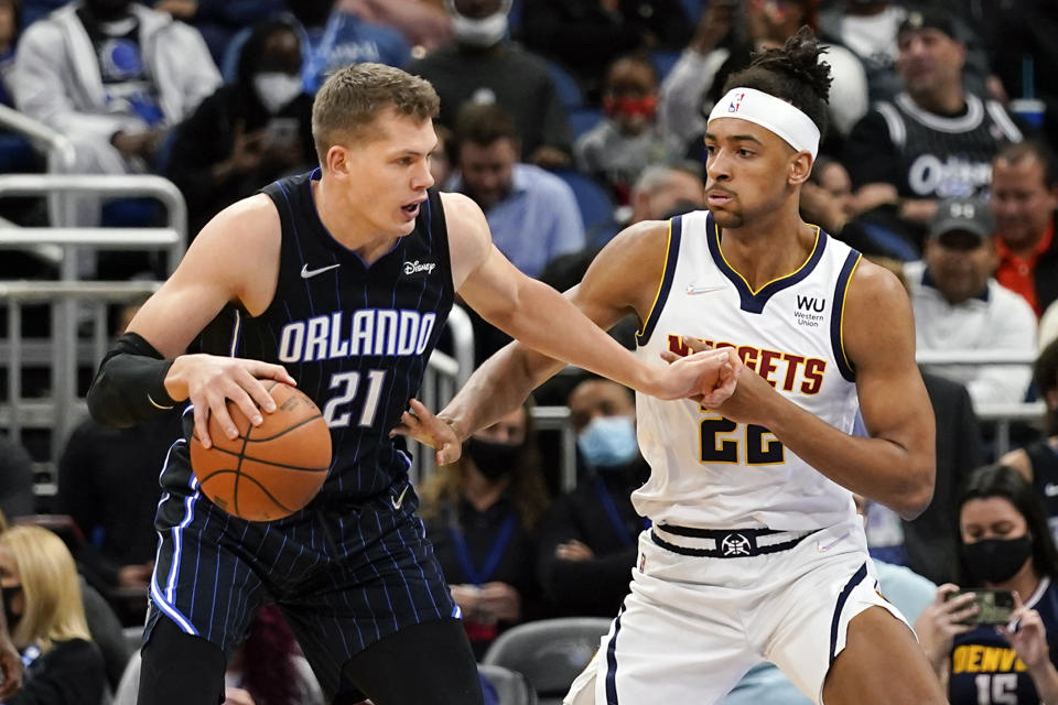 Orlando Magic center Moritz Wagner (21) makes a move to the basket against Denver Nuggets forward Zeke Nnaji, right, during the first half of an NBA basketball game, Wednesday, Dec. 1, 2021, in Orlando, Fla. (AP Photo/John Raoux)