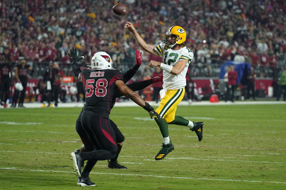 Green Bay Packers quarterback Aaron Rodgers (12) throws under pressure from Arizona Cardinals middle linebacker Jordan Hicks (58) and defensive tackle Jordan Phillips during the first half of an NFL football game, Thursday, Oct. 28, 2021, in Glendale, Ariz. (AP Photo/Rick Scuteri)