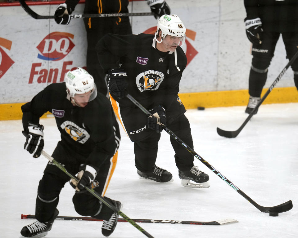 Pittsburgh Penguins' Sidney Crosby (87) and former Penguins player Jaromir Jagr (68) run a drill during NHL hockey practice Saturday, Feb. 17, 2024 in Cranberry, Pa. Jagr, who spent 11 seasons playing for the Penguins, will have his No. 68 officially retired during a pre-game ceremony before an NHL hockey game between the Los Angeles Kings and the Penguins on Sunday. (AP Photo/Gene J. Puskar)