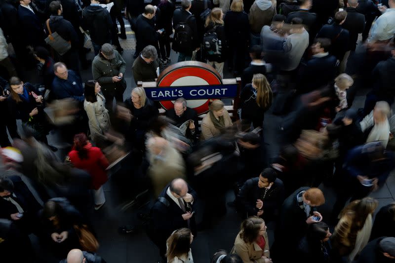 Commuters wait on the platform at Earls Court tube station on the London underground