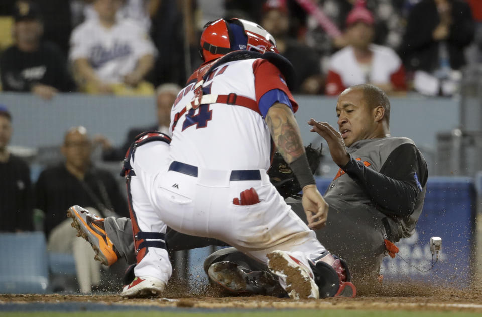 Puerto Rico catcher Yadier Molina, left, tags out Netherlands' Jonathan Schoop, who tried to score on a hit by Shawn Zarraga during the fifth inning of a semifinal in the World Baseball Classic in Los Angeles, Monday, March 20, 2017. (AP Photo/Chris Carlson)