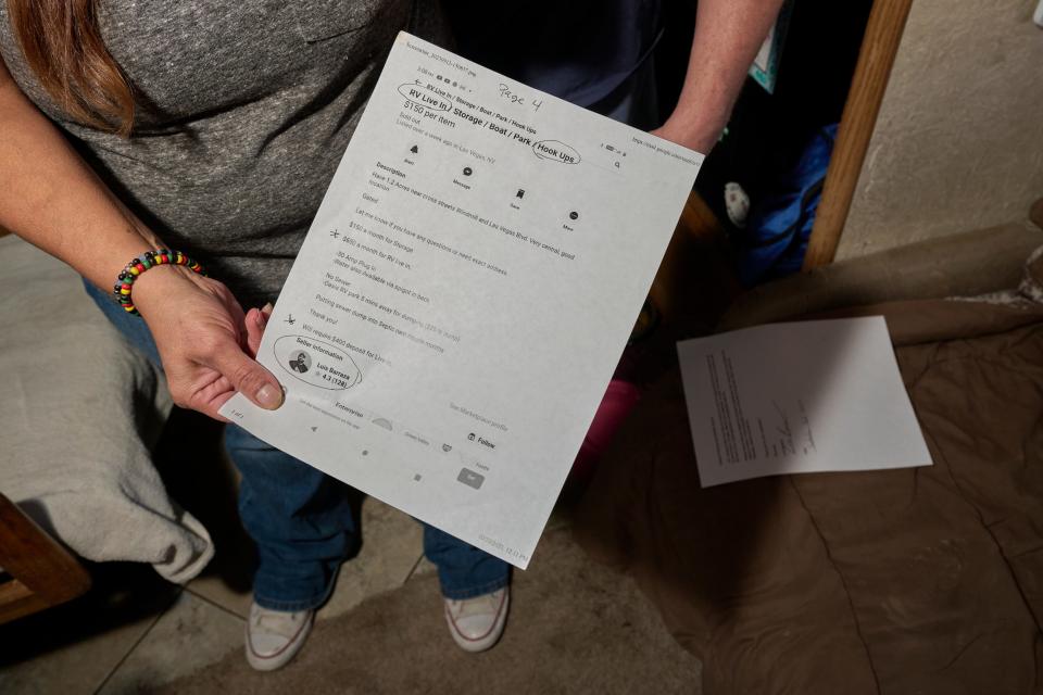 A woman holds a printed out Facebook ad of trailer for rent.