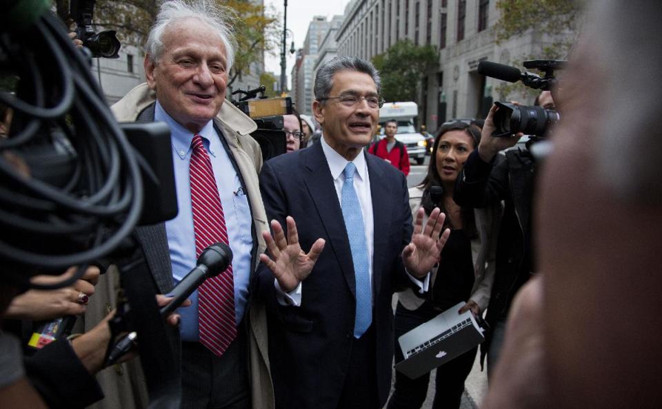 Rajat Gupta, center, leaves federal court in New York on Wednesday, Oct. 24, 2012 after the former Goldman Sachs and Procter & Gamble Co. board member was sentenced Wednesday to 2 years in prison for feeding inside information about board dealings with a billionaire hedge fund owner who was his friend. At left is Gupta's attorney, Gary Naftalis. (AP Photo/Craig Ruttle)