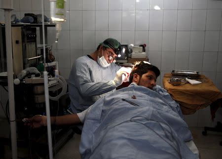 Plastic surgeon Abdul Ghafar Ghayur performs surgery on a patient at Aria City Hospital, in Kabul, Afghanistan August 6, 2015. REUTERS/Ahmad Masood