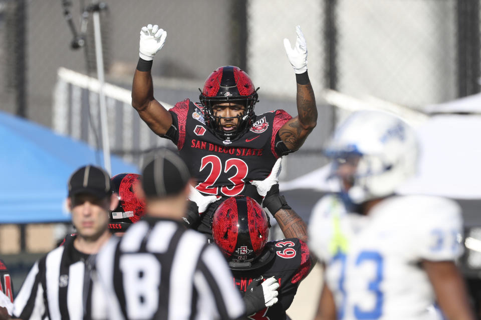 San Diego State cornerback Dezjhon Malone (32) is hoisted by teammates after he made a touchdown against Middle Tennessee during the first half of the Hawaii Bowl NCAA college football game, Saturday, Dec. 24, 2022, in Honolulu. (AP Photo/Marco Garcia)