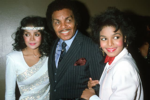 <p>Michael Ochs Archives/Getty</p> Joe Jackson (center) with daughters LaToya and Janet Jackson in 1983