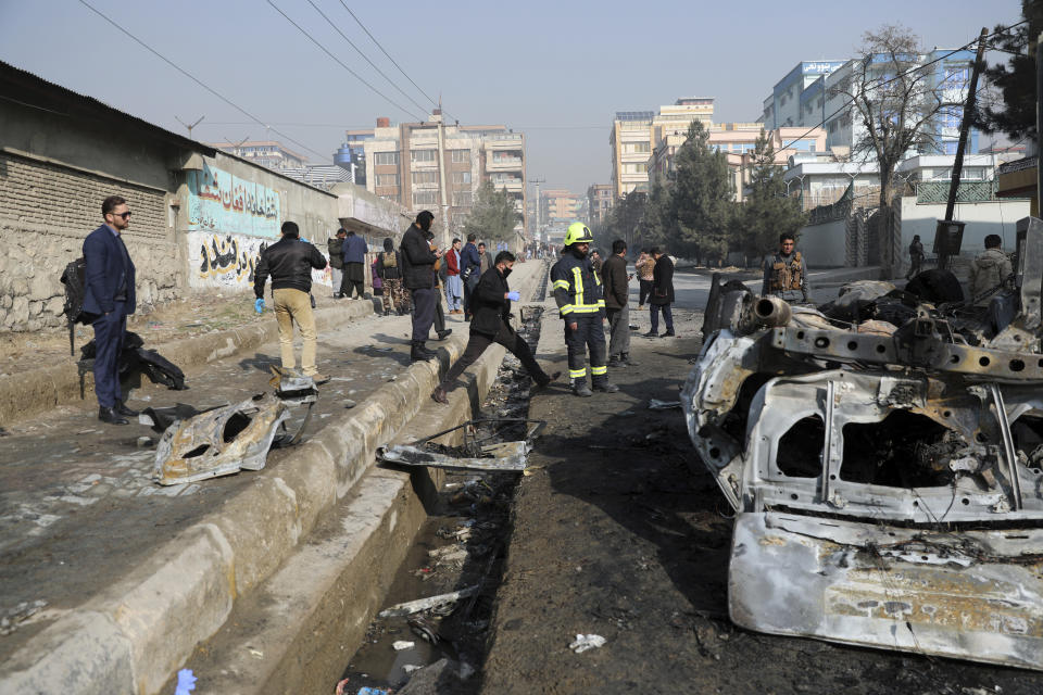 Afghan security officers inspect the site of a bombing attack in Kabul, Afghanistan, Sunday, Jan. 10, 2021. A roadside bomb exploded in Afghanistan's capital Sunday, killing at least a few people in a vehicle, the latest attack to take place even as government negotiators are in Qatar to resume peace talks with the Taliban. (AP Photo/Rahmat Gul)