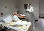 Dr. Joseph Varon, right, talks with patient Jose Tellez while making his rounds inside the Coronavirus Unit at United Memorial Medical Center, Monday, July 6, 2020, in Houston. Varon has worked more than 100 days with barely a rest and normally sleeps just a few hours a night. (AP Photo/David J. Phillip)