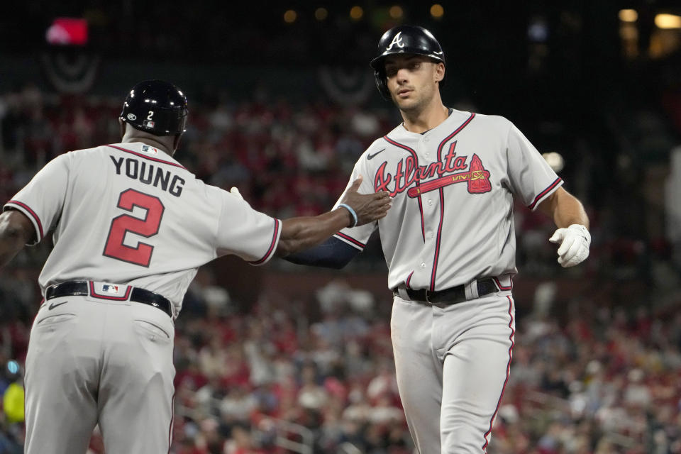 Atlanta Braves' Matt Olson, right, is congratulated by first base coach Eric Young Sr. (2) after hitting an RBI single during the seventh inning of a baseball game Monday, April 3, 2023, in St. Louis. (AP Photo/Jeff Roberson)