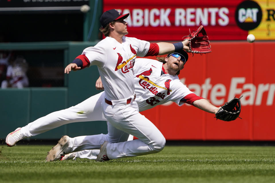 St. Louis Cardinals second baseman Nolan Gorman, front, and right fielder Brendan Donovan (33) are unable to catch a foul ball by Milwaukee Brewers' Lorenzo Cain during the sixth inning of a baseball game Sunday, May 29, 2022, in St. Louis. (AP Photo/Jeff Roberson)