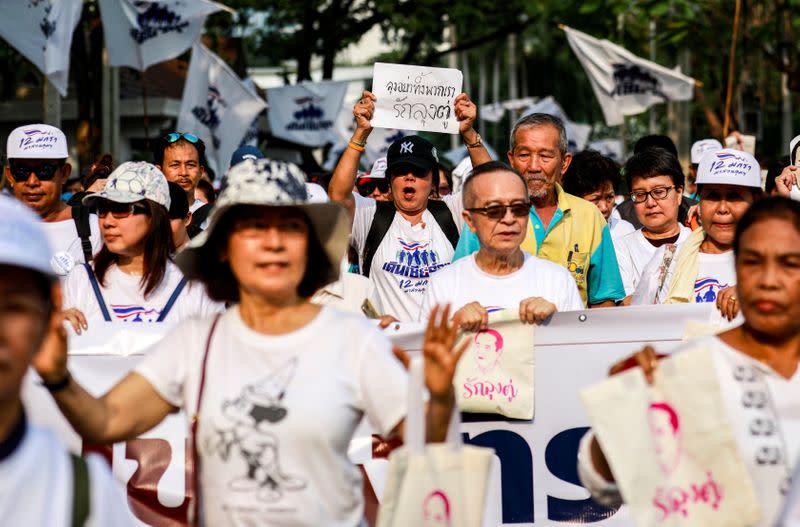 Supporters of Thailand’s Prime Minister Prayut Chan-o-cha walk as they support their support for the government at a park in Bangkok