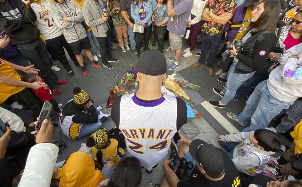 Fans mourn the loss of Kobe Bryant with makeshift memorials in front of La Live across from Staples Center, home of the Los Angeles Lakers in Los Angeles on Sunday, Jan, 26, 2020. Bryant, the 18-time NBA All-Star who won five championships and became one of the greatest basketball players of his generation during a 20-year career with the Los Angeles Lakers, died in a helicopter crash Sunday. (Keith Birmingham/The Orange County Register via AP)