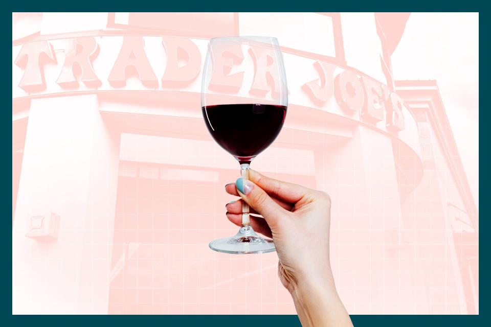 A woman holding a glass of wine in front of a Trader Joe's storefront