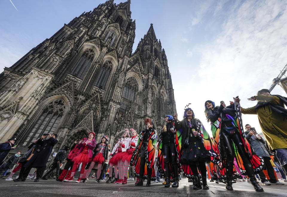 Revellers dance in front of the Cologne Cathedral at the start of the street carnival in Cologne, Germany, Thursday, Feb. 16, 2023. Hundreds of thousands will celebrate the carnival without any coronavirus restrictions in the streets of the German carnival capital. (AP Photo/Martin Meissner)