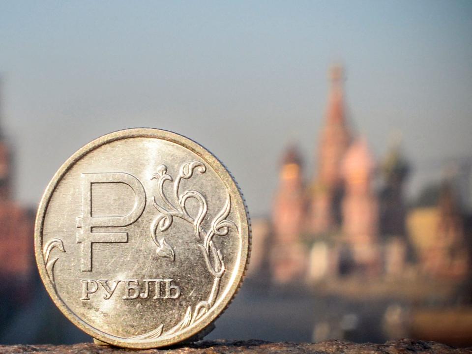 A Russian ruble coin is pictured in front of the Kremlin in central Moscow, on April 28, 2022.