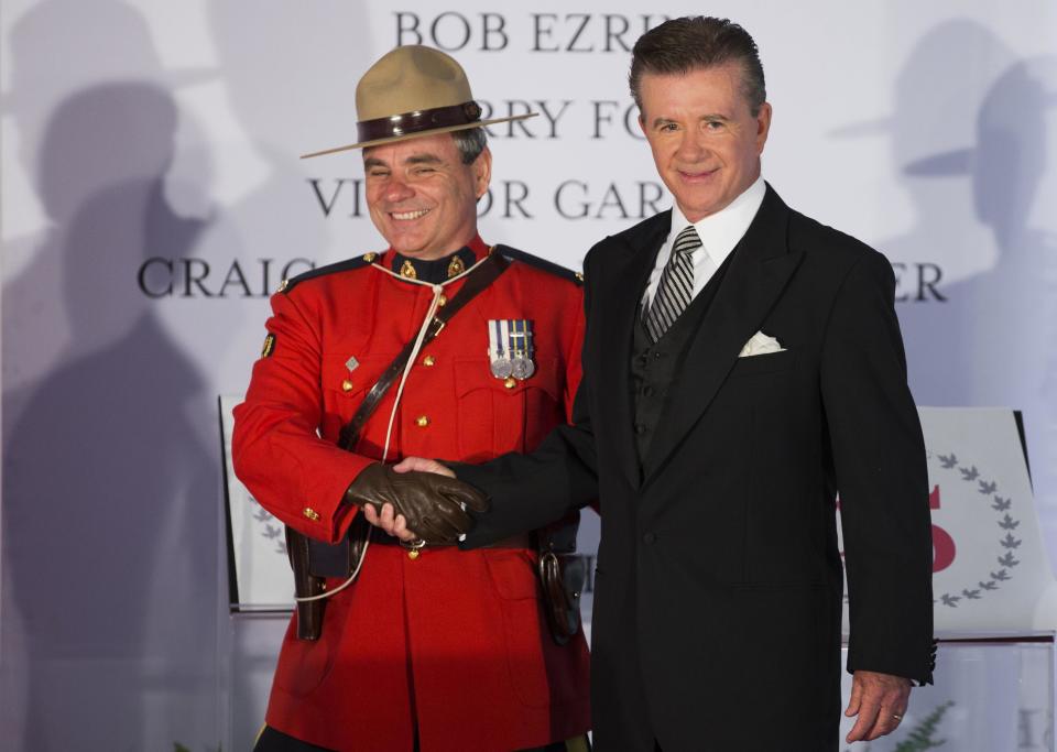 Actor and honouree Alan Thicke shakes hands with a Royal Canadian Mounted Police officer during Canada's Walk of Fame induction ceremonies in Toronto, September 21, 2013. REUTERS/Mark Blinch (CANADA - Tags: ENTERTAINMENT)