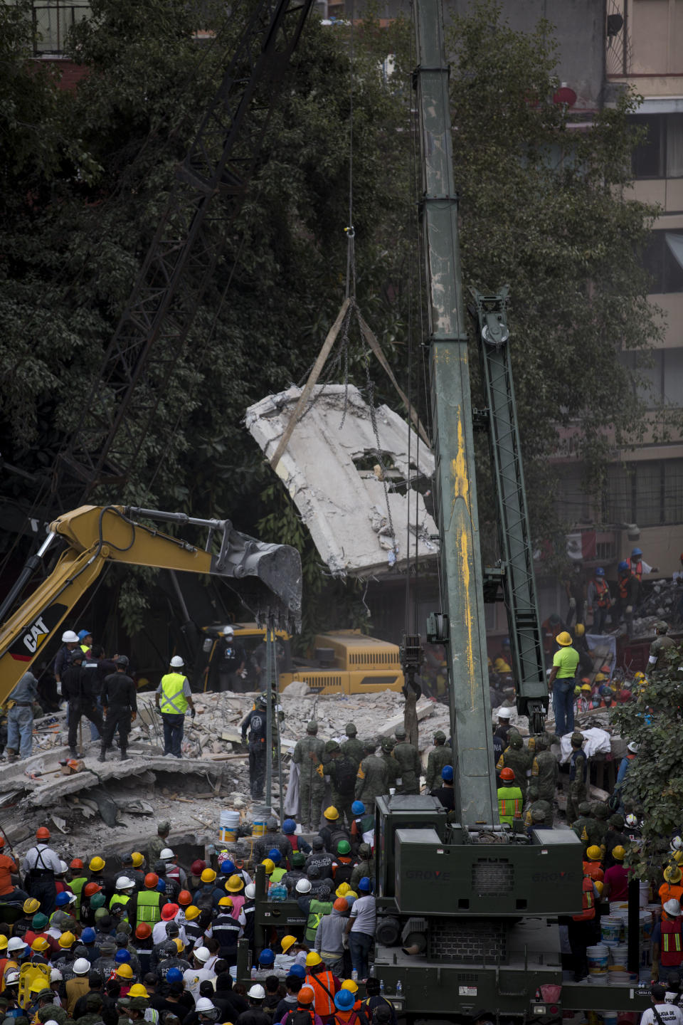 <em>A crane moves a piece of a collapsed building, a day after a devastating 7.1 earthquake (AP)</em>
