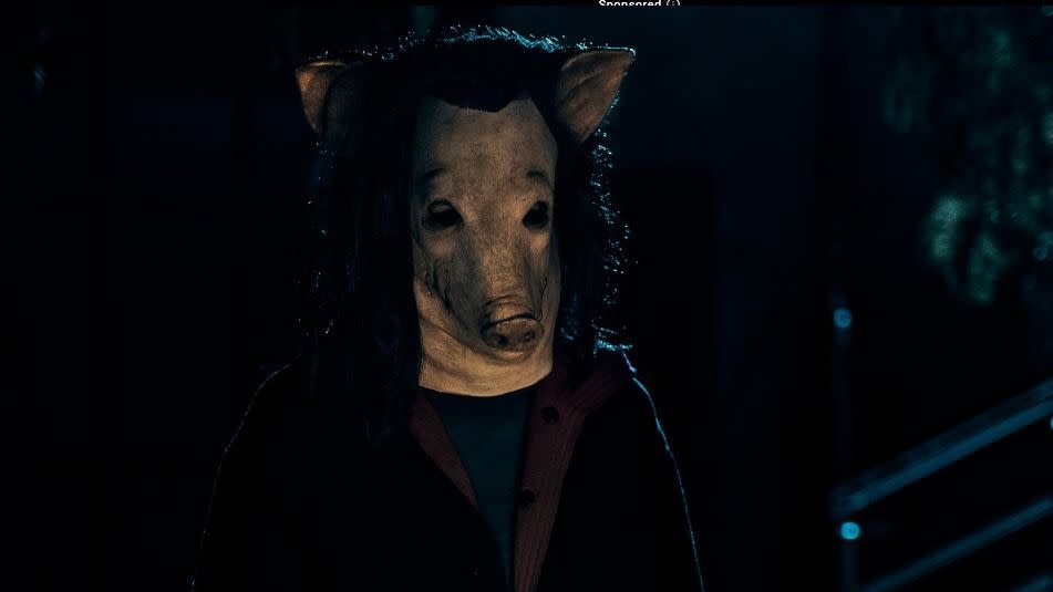 a person wears a realistic pig mask in a scene from saw x