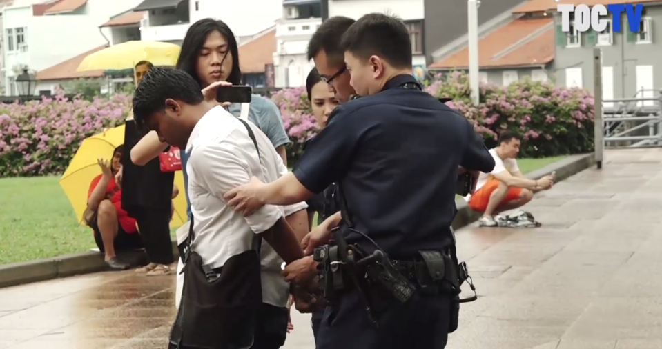 Activist and artist Seelan Palay was arrested outside Parliament House on 1 October 2017 by police officers. (PHOTO: Screenshot of video from The Online Citizen Facebook page)