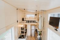 Una escalera situada en la encimera de la cocina permite acceder a la habitación de los dos niños de la familia. (Foto: <a href="http://www.buildtiny.co.nz/kahurangi-koinga-tiny-house" rel="nofollow noopener" target="_blank" data-ylk="slk:Build Tiny;elm:context_link;itc:0;sec:content-canvas" class="link ">Build Tiny</a>).