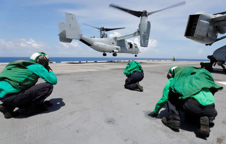 Crewmen brace themselves from the propeller wash of a Marine Corps MV-22B Osprey departing the aboard the USS Kearsarge as U.S. military continues to evacuate from the U.S. Virgin Islands in advance of Hurricane Maria, in the Caribbean Sea near the islands. REUTERS/Jonathan Drake