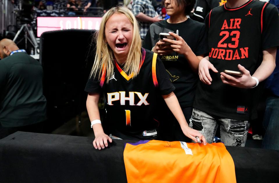 Apr 29, 2023; Denver, CO, USA;  Zoey Kirksey, age 11 from Rapid City, SD, weeps after Phoenix Suns guard Devin Booker signed her jersey during the pregame warmup before Game 1 of the Western Conference Semifinals at Ball Arena. Mandatory Credit: Rob Schumacher-Arizona Republic