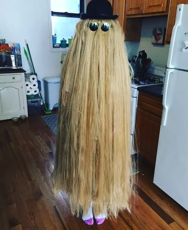 Someone dressed as Cousin Itt, covered in long straw/hair