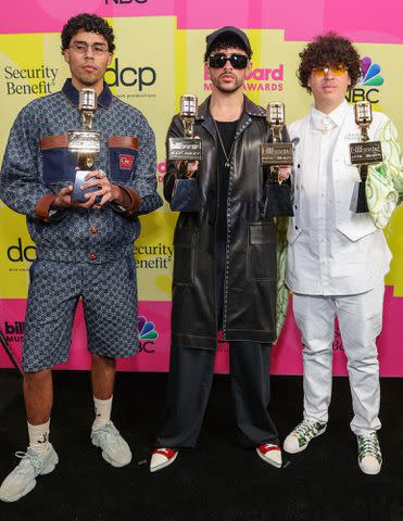 <p>Rich Fury/Getty</p> Bad Bunny with his brothers Bysael and Bernie Martinez Ocasio, backstage at the 2021 Billboard Music Awards in May 2021 in Los Angeles, California.