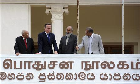 Britain's Prime Minister David Cameron (2nd L), Chief Minister of Northern province, C. V. Vigneswaran (2nd R) and Sri Lankan Tamil National Alliance (TNA) party leader R. Sampanthan (L) talk while looking out from the public library in Jaffna, about 400 km (250 miles) north of Colombo November 15, 2013. REUTERS/Stringer