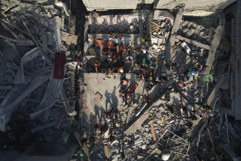 Palestinos inspeccionan los escombros de edificios alcanzados por un ataque aéreo israelí en el campo de refugiados Al Shati, el 12 de octubre de 2023. (AP Foto/Hatem Moussa)