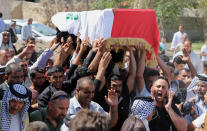 Mourners chant slogans against the al-Qaida breakaway group Islamic State of Iraq and the Levant (ISIL), while carrying a flag-draped coffin of Ammar Tueni, 24, a policeman killed in a car bomb attack during his funeral procession in Hillah, about 60 miles (95 kilometers) south of Baghdad, Iraq, Thursday, April 24, 2014. The Shiite-dominated city of Hillah has seen sporadic violence recently. Last month, a suicide car bomber hit another checkpoint in same area, killing 36 people. Iraq has seen a spike in violence since last year, with the death toll climbing to its highest levels since the worst of the country's sectarian bloodletting between 2006 and 2008. The U.N. says 8,868 people were killed in 2013, and more than 1,400 people were killed in the first two months of this year. (AP Photo/Karim Kadim)