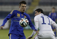 Yevhen Konoplianka, left, of Ukraine controls the ball with Alejandro Bedoya of U.S. during an international friendly match at Antonis Papadopoulos stadium in southern city of Larnaca, Cyprus, Wednesday, March 5, 2014. The Ukrainians are facing the United States in a friendly on Wednesday in Cyprus, a match moved from Kharkiv to Larnaca for security reasons. (AP Photo/Petros Karadjias)