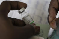A health worker holds an empty vial of the China's Sinopharm vaccine during the start of the vaccination campaign against the COVID-19 at the Health Ministry in Dakar, Senegal, Tuesday, Feb. 23, 2021. The country is also expecting nearly 1.3 million vaccine doses through the COVAX initiative. (AP Photo/Leo Correa)