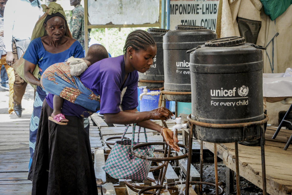 Women coming from Congo wash their hands with chlorinated water to prevent the spread of infection, at the Mpondwe border crossing with Congo, in western Uganda Friday, June 14, 2019. In Uganda, health workers had long prepared in case the Ebola virus got past the screening conducted at border posts with Congo and earlier this week it did, when a family exposed to Ebola while visiting Congo returned home on an unguarded footpath. (AP Photo/Ronald Kabuubi)