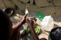 Frena Remorin, 30, peels a sweet potato in the improvised kitchen in the yard of her house in Jean-Rabel