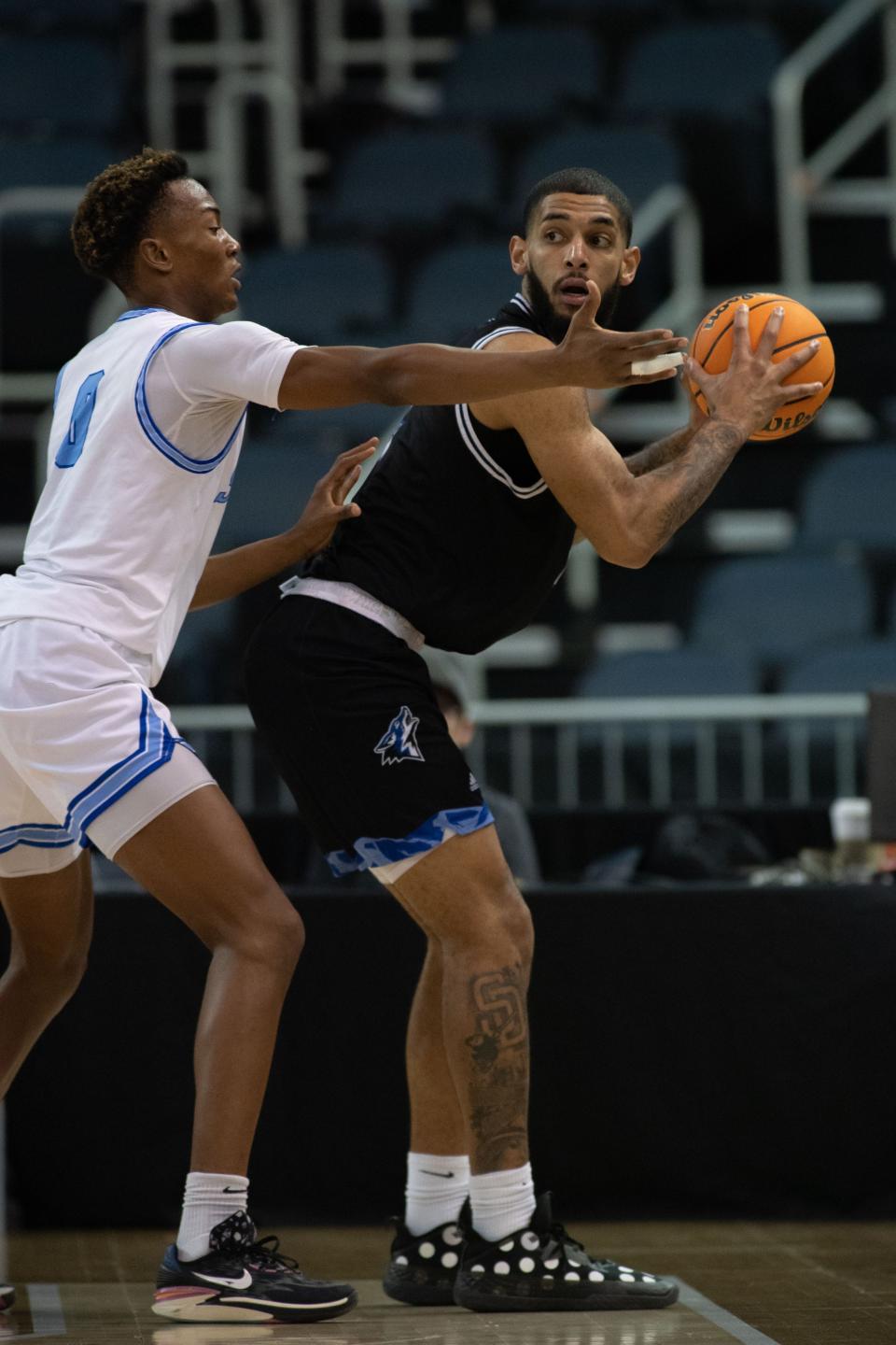 Cal State San Bernardino's Robby Robinson (4) looks for an opening to pass the ball around Nova Southeastern's Jonathan Pierre (0) during the semifinal round of the 2023 NCAA Division II Men’s Elite Eight tournament at Ford Center in Downtown Evansville, Ind., Thursday afternoon, March 23, 2023. 