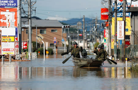 Japan Self-Defense Force soldiers ride a boat during their rescue work at a flooded area in Mabi town in Kurashiki, Okayama Prefecture, Japan, July 8, 2018. REUTERS/Issei Kato