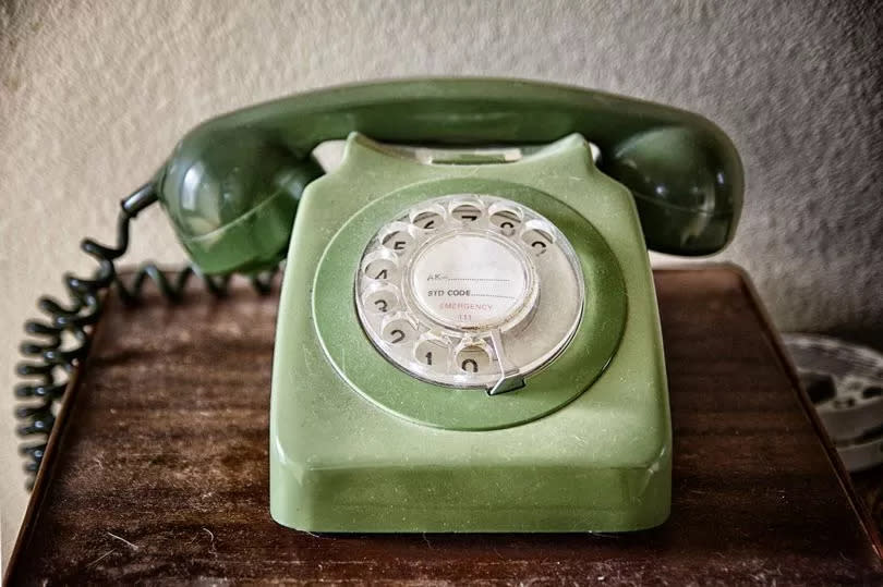 Close up of an old telephone on the table. Vintage telephone with rotary dial. Communication concept.