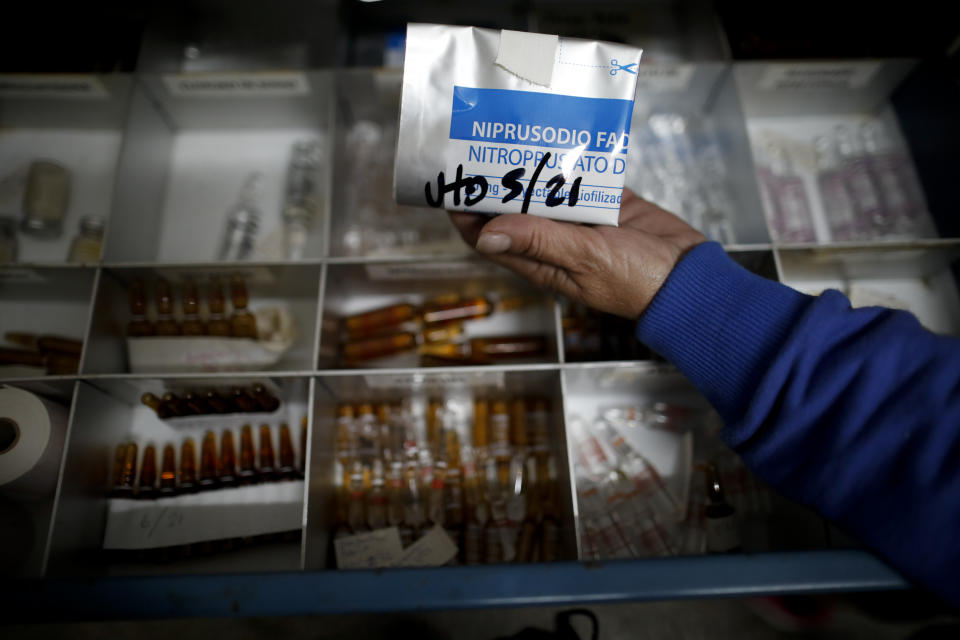 Chief of Surgical Services Alicia Rey shows medicine inside the ICU of the San Andres Clinic which has been occupied by its former workers since it closed at the start of the year following the death of the hospital's director and owner in Caseros, Argentina, Friday, April 30, 2021. While the pandemic has swelled the need for hospital beds, many private clinics say they're struggling to survive, citing the pandemic having pushed away many non-COVID patients and losing money on coronavirus sufferers because the government insurance program doesn't pay enough to meet costs. (AP Photo/Natacha Pisarenko)