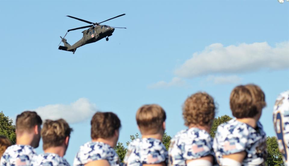 Gaylord's football team watches a flyover from a Blackhawk helicopter before Gaylord's 37-16 victory over Marquette in the team's third annual Valor Game on Saturday, Sept. 9 in Gaylord, Mich.