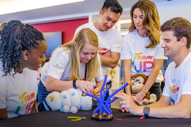 <p>Comcast</p> Employees participate in a project at the Comcast Center in Philadelphia, rewiring toys so children working with Easterseals can play independently.