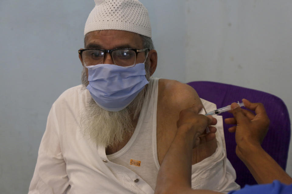 A man receives the second shot of the AstraZeneca COVID-19 vaccine from a health worker at a vaccination center in Lahore, Pakistan, Sunday, May 16, 2021. (AP Photo/K.M. Chuadary)