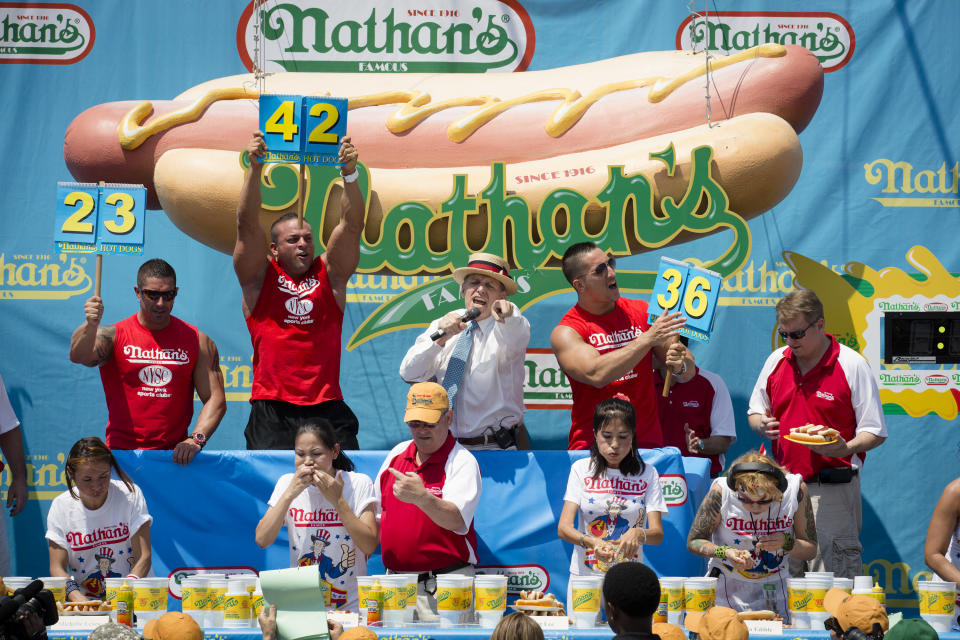 Competitors at Nathan's Famous Women's Hot Dog Eating World Championship gorge themselves against the clock, Wednesday, July 4, 2012, at Coney Island, in the Brooklyn borough of New York. Sonya Thomas beat her own record by gobbling down 45 hot dogs and buns in 10 minutes to win the women's competition at the annual Coney Island contest. (AP Photo/John Minchillo)