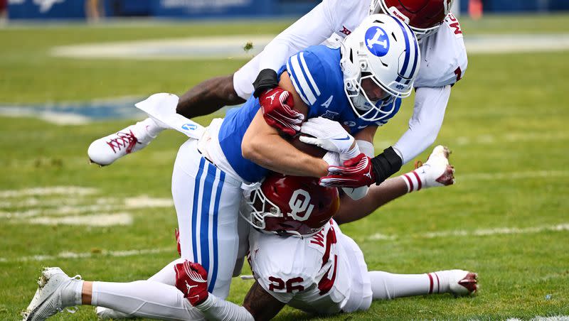 Brigham Young Cougars wide receiver Chase Roberts (2) makes the catch for a touchdown with Oklahoma Sooners defensive back Kani Walker (26) and linebacker Dasan McCullough (1) hanging on as BYU and Oklahoma play at LaVell Edwards Stadium in Provo on Saturday, Nov. 18, 2023.