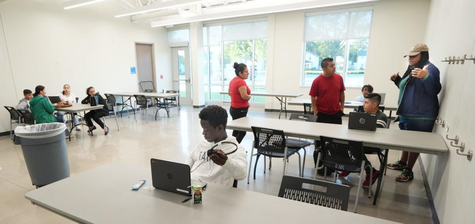 As the Columbus City Schools teacher strike moves into the third day, recreation and parks staffer Ambrosia Lamarr (right) helps Asher Aquino, 11, log in at the Linden Recreation Center. Behind Asher are his parents, Antonio Vargas and Graciela Aquino. Asher is the sixth grade at World Language Middle School.  In the foreground is Chernor Bah, 13, a Columbus Alternative High School freshman.